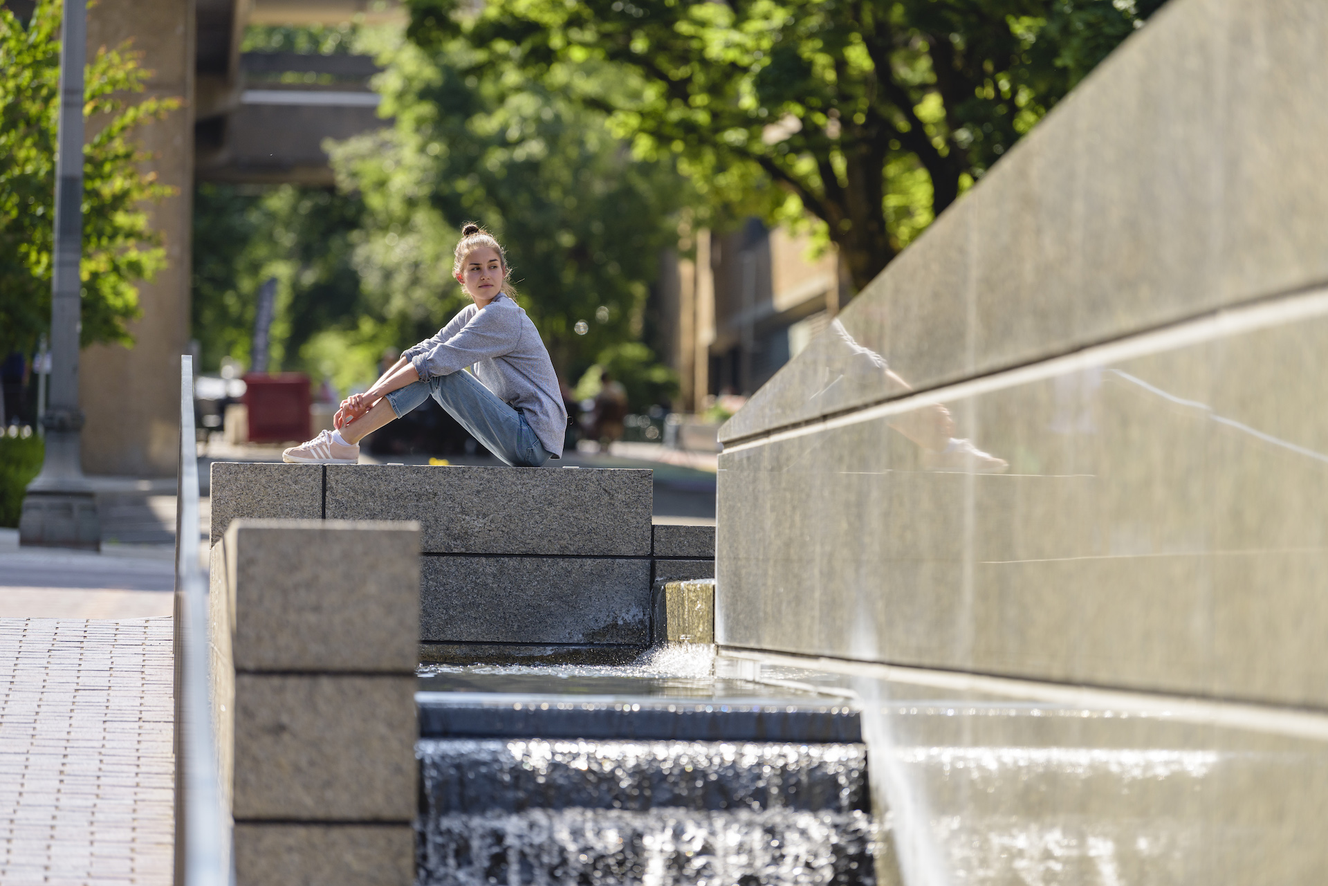 PSU online student sitting by a fountain