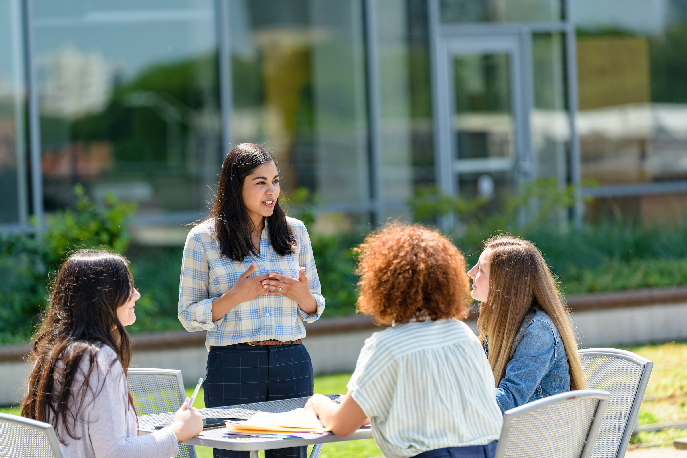 Group of students talking at table on rooftop