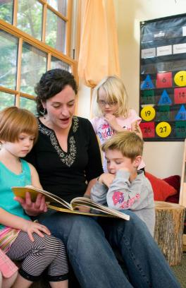 Teacher reading book to young children