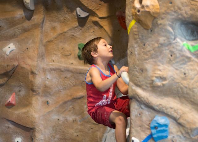 A youth member boulders on the Climbing Wall.