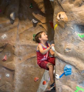 A youth member boulders on the Climbing Wall.
