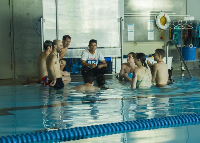 A group of people standing in the pool. 