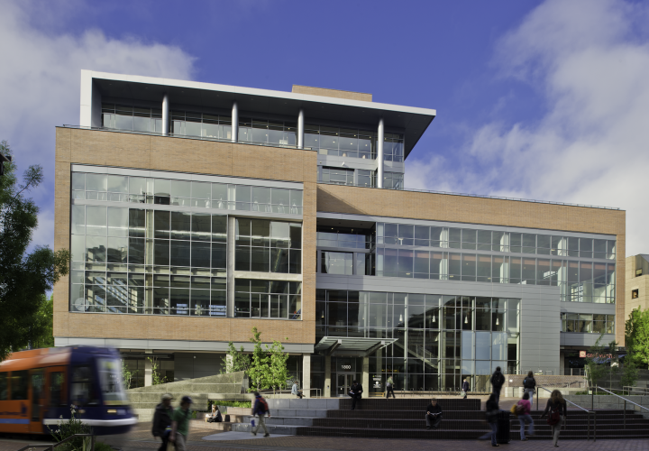 North exterior of the ASRC building with the Urban plaza and streetcar in front and people walking on a day with blue skies