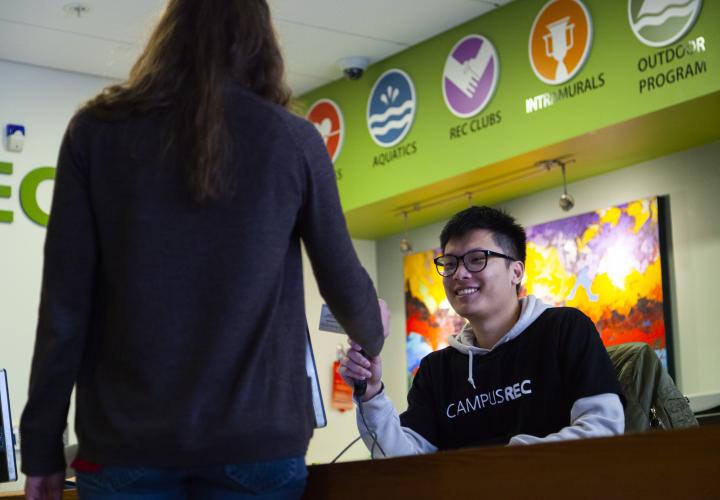 Student scanning ID card at the Membership Services desk. 