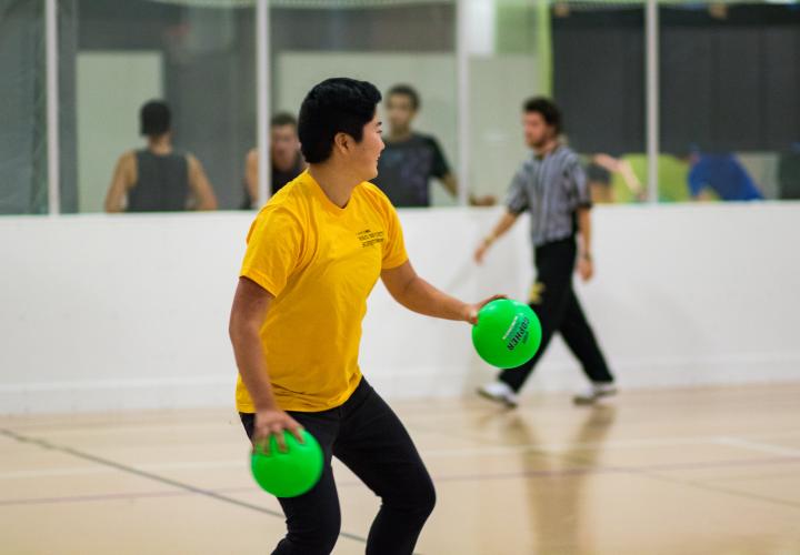 Man playing in a dodgeball tournament at the Rec Center.