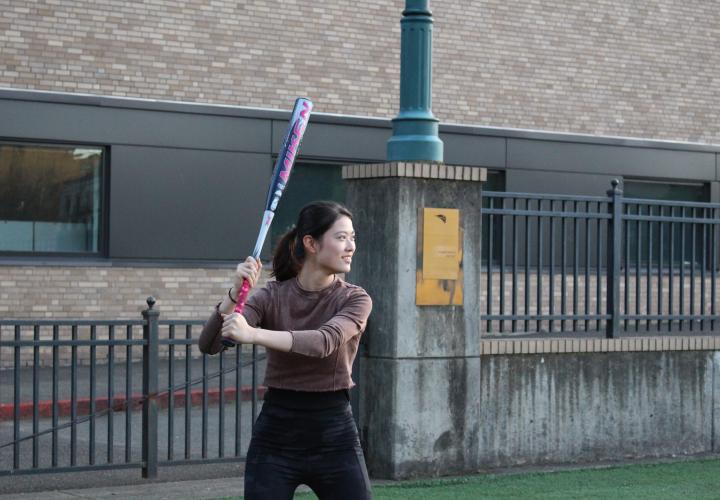 A person holding and getting to swing a baseball bat. 