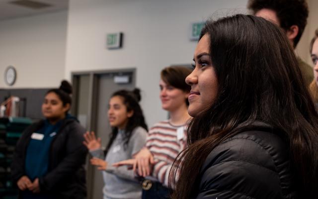 A group of students listening to someone outside of the photo. 