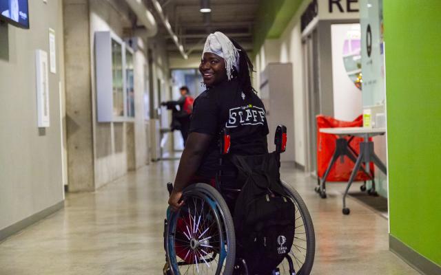 Student in a wheelchair wearing a staff shirt. 