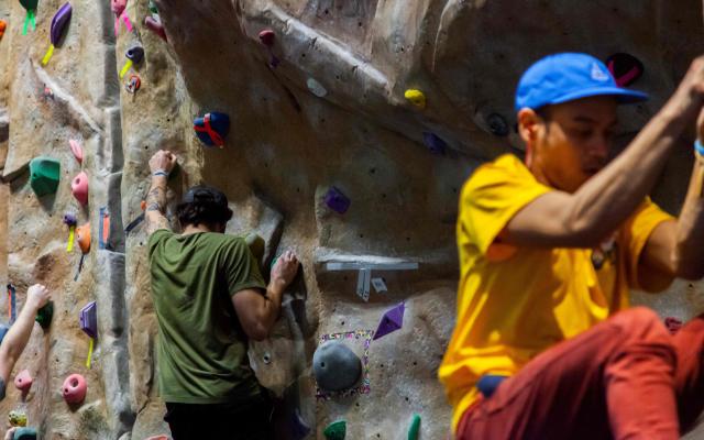 Two people climbing the rock wall