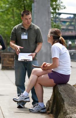 Researcher interviewing person on sidewalk