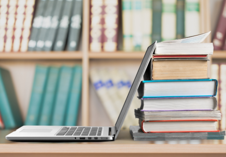 A laptop and books on a desk
