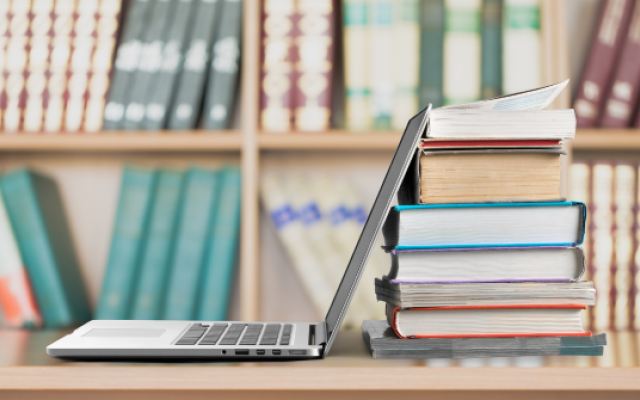 A laptop and books on a desk