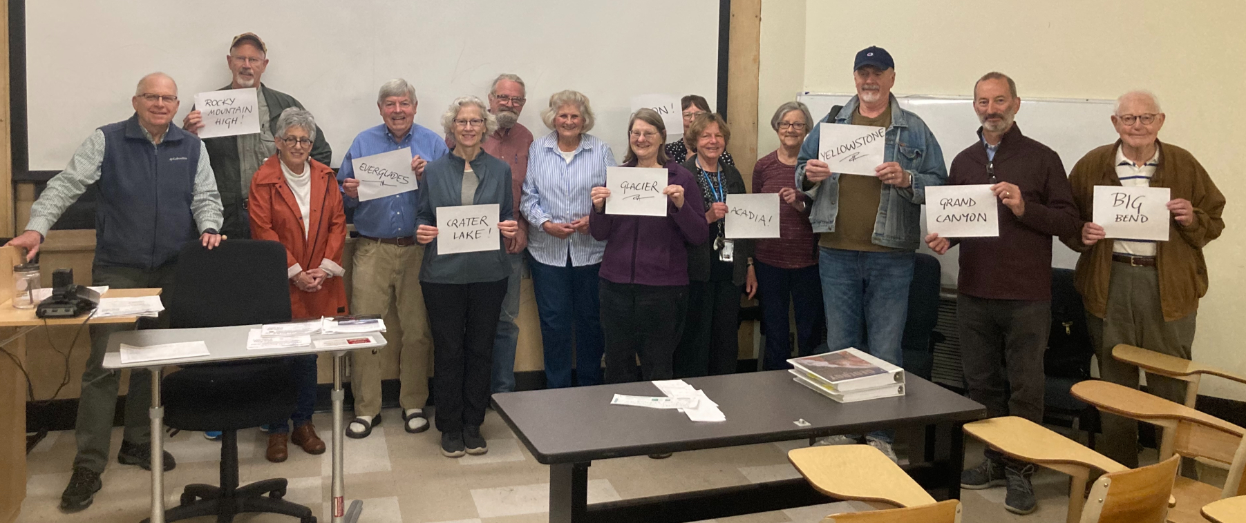 Photo of Dr. Burns with auditors holding signs with names of national parks