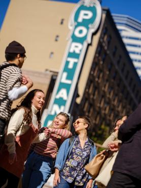 Students hanging out on Broadway in front of the Portland theater sign