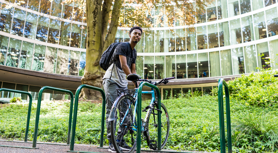 Cyclist parking bike outside of PSU library 