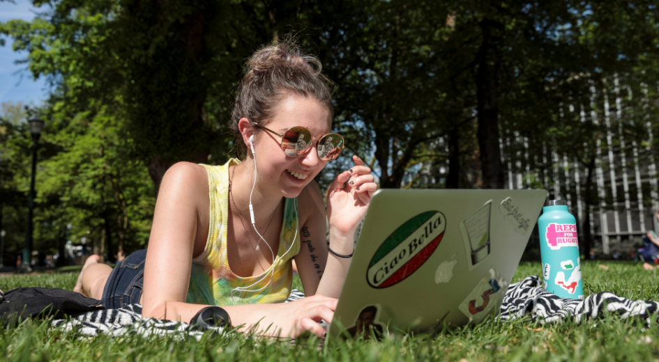 student looking at laptop on south park blocks