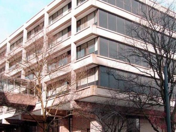 The image is of a building with trees around it.