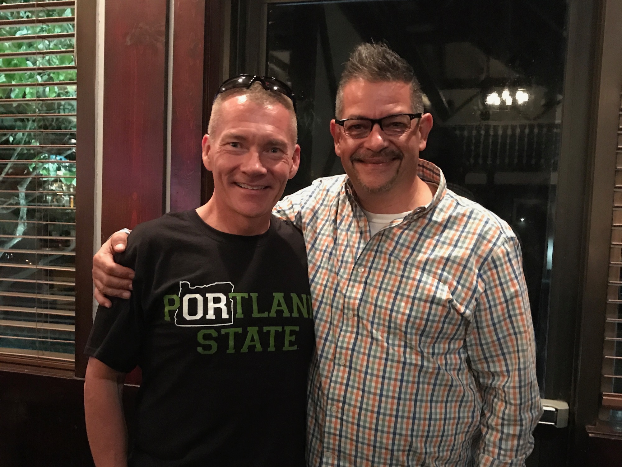 The image is of two people standing together smiling.
