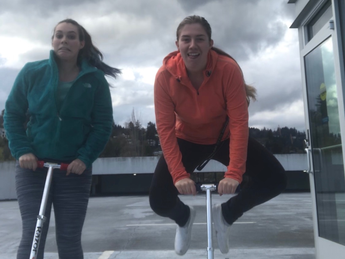 The image is of two people on razor scooters. 