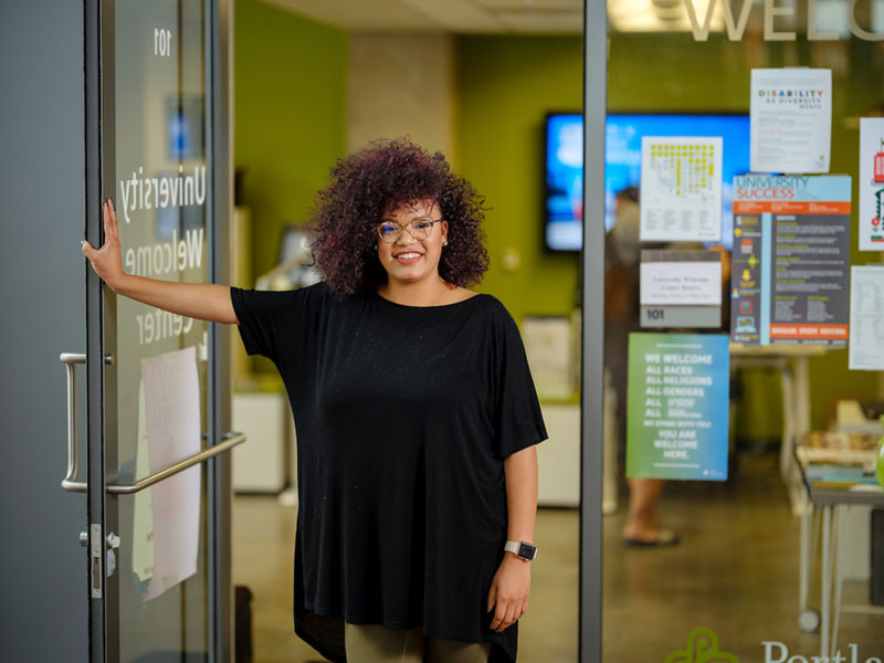 student standing at the University Welcome Center door