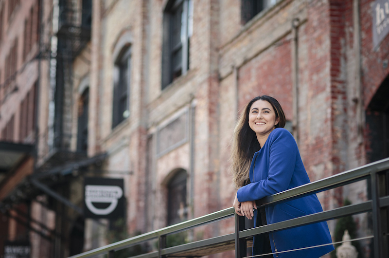 Student relaxing on the balcony of her apartment on campus