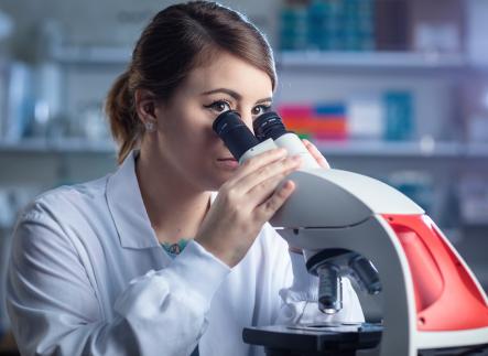 woman looking into microscope
