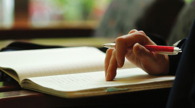 Close up of a student writing in a notebook