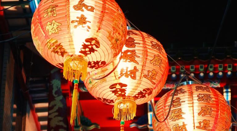 three lit chinese hanging lanterns