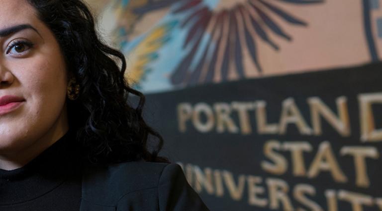 Woman in front of mural with PSU sign