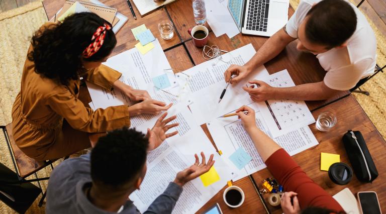 People working at a table together doing Business Economics 