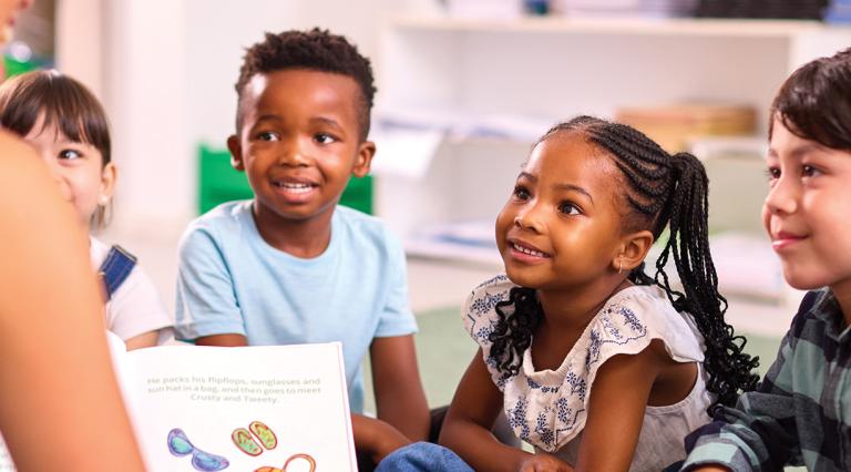 Students in an elementary schools classroom listening to a book