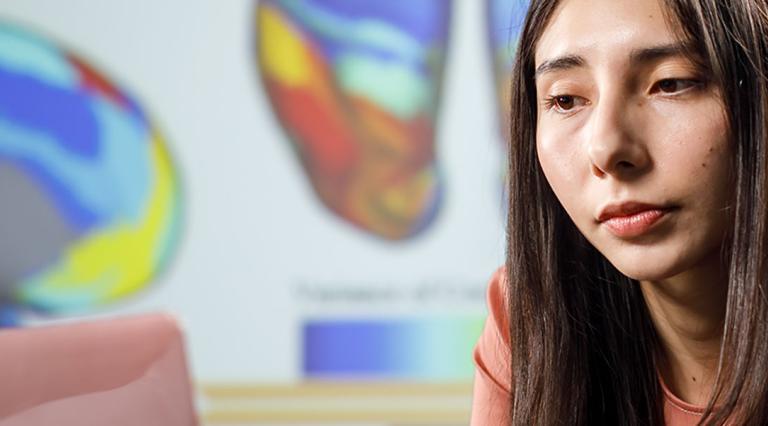 Student looking at images of the brain on her laptop