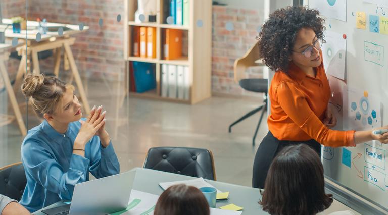 Woman in an office instructing colleagues
