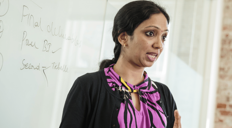 graduate student standing in front of classroom speaking
