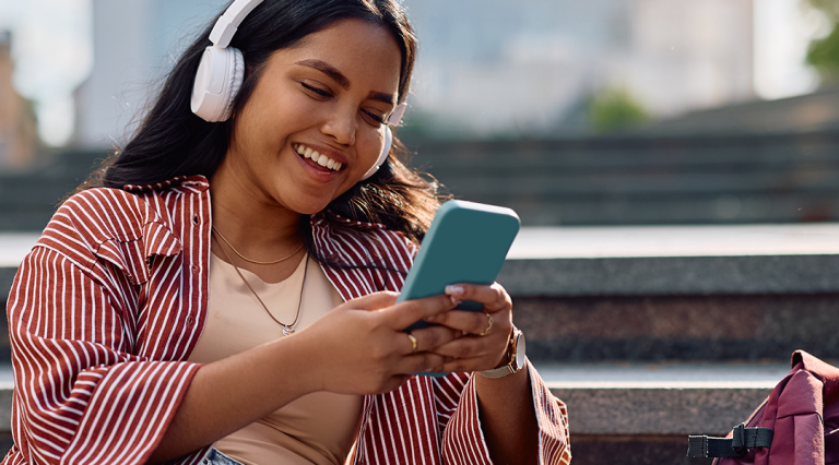 Student laughing and looking at their phone