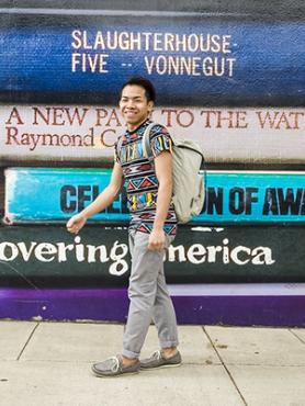 PSU student in front of a mural