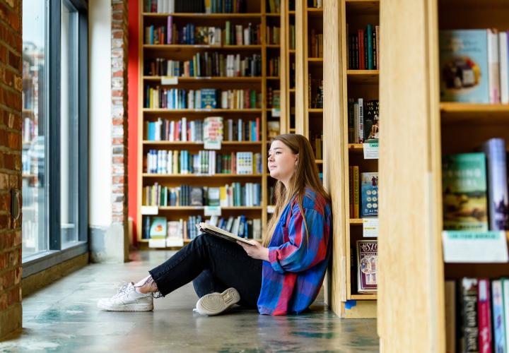 Student on the floor with a book at Powells Books