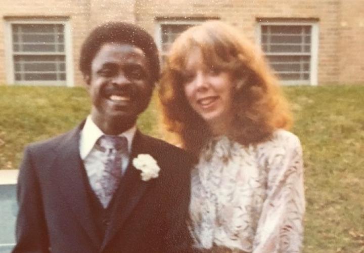 The image is of two people standing outside. 