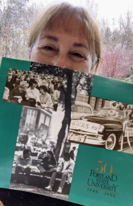 There is a person holding up old Portland State memories on a green page.