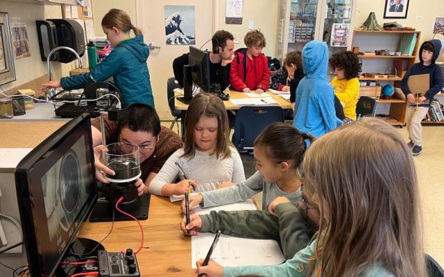 Natalie Frank works with students at The Portland Montessori School to test an experiment.