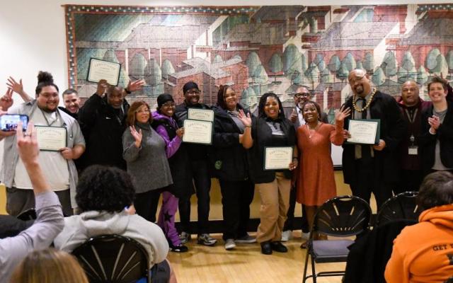 Community Safety Worker Certificate graduates hold certificates and celebrate with program organizers in the Smith Memorial Student Union