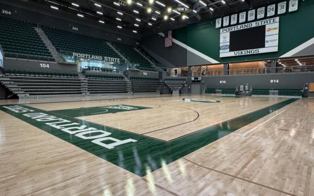 An empty basketball court inside the Viking Pavilion with Portland State Vikings branding on the floor and scoreboard