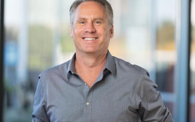 Martin Siderius smiling in a grey button-down shirt