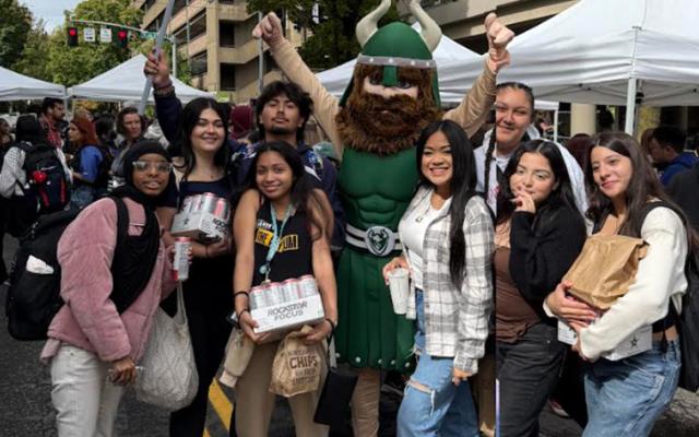 Students and Victor Viking mascot posing at the SHAC Block Party