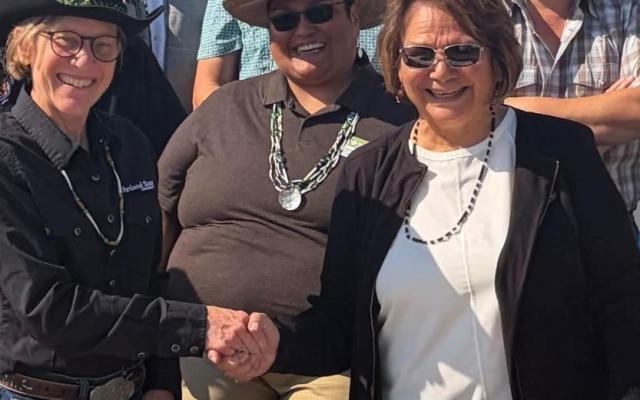 PSU President Ann Cudd shakes hands with Confederated Tribes of the Umatilla Indian Reservation Board Chair N. Kathryn Brigham at the Pendleton Round-Up