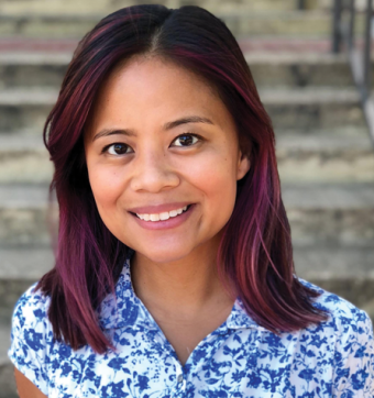 Dr. Sevillano, a cisgender Pilipinx woman smiling proudly and standing in front of some steps.