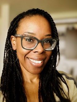 Smiling black woman with braided hair and glasses