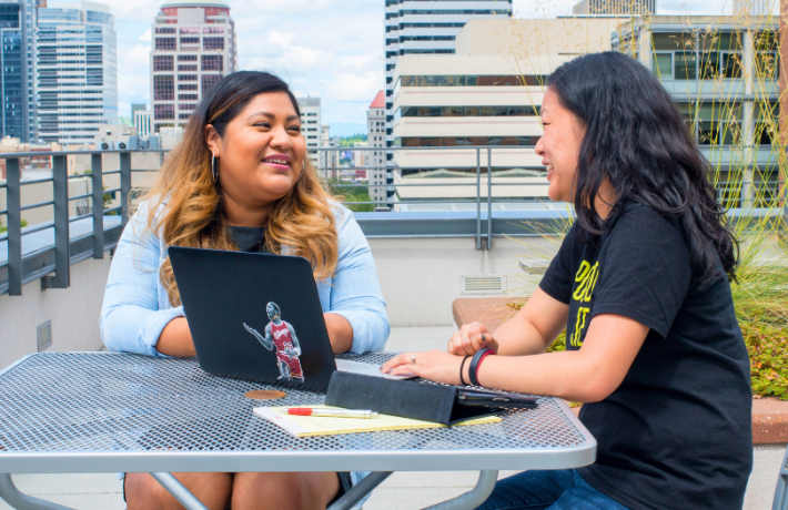 Student and professor sitting and talking on ASRC building terrace