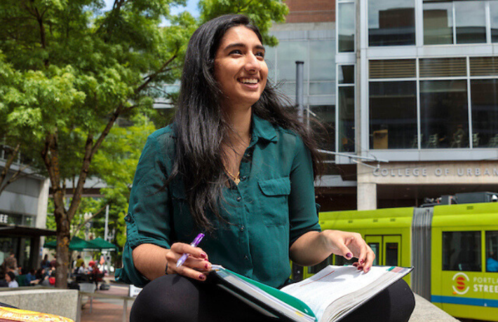 Student sitting with book in PSU Urban Plaza