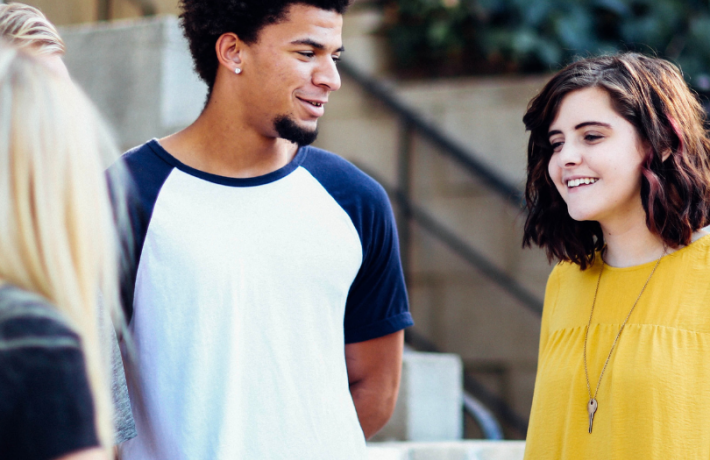 Students talking on sidewalk near stairs